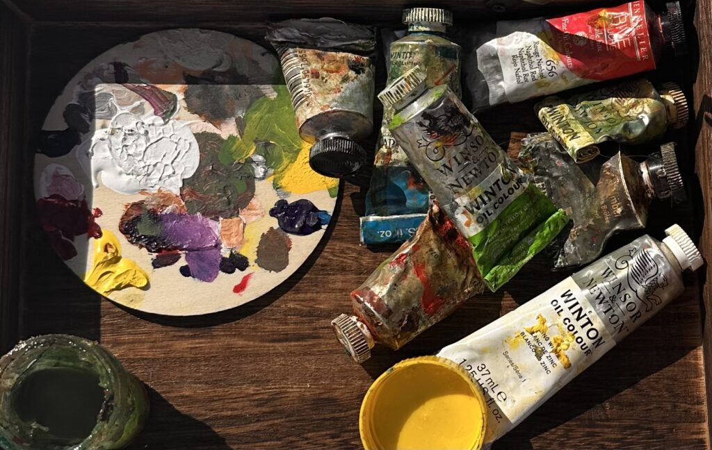 paint tubes and a palette on wood